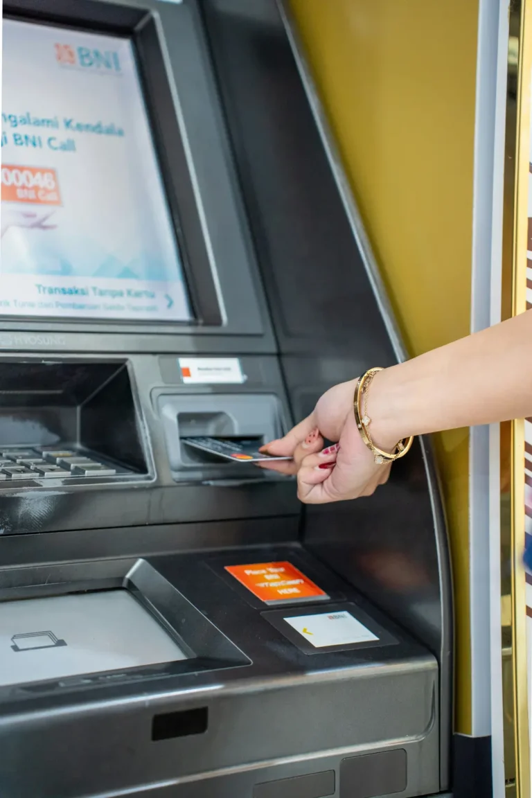 Traveller inserting a bank card into an ATM