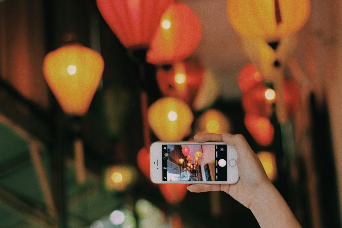 Traveler using a smartphone under lanterns in Hanoi, Vietnam