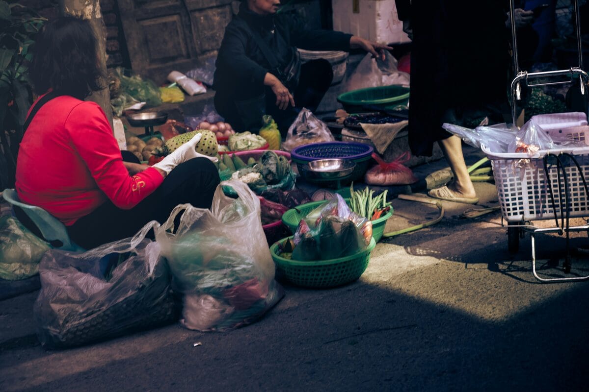 People buying fresh produce at a street market in Hanoi