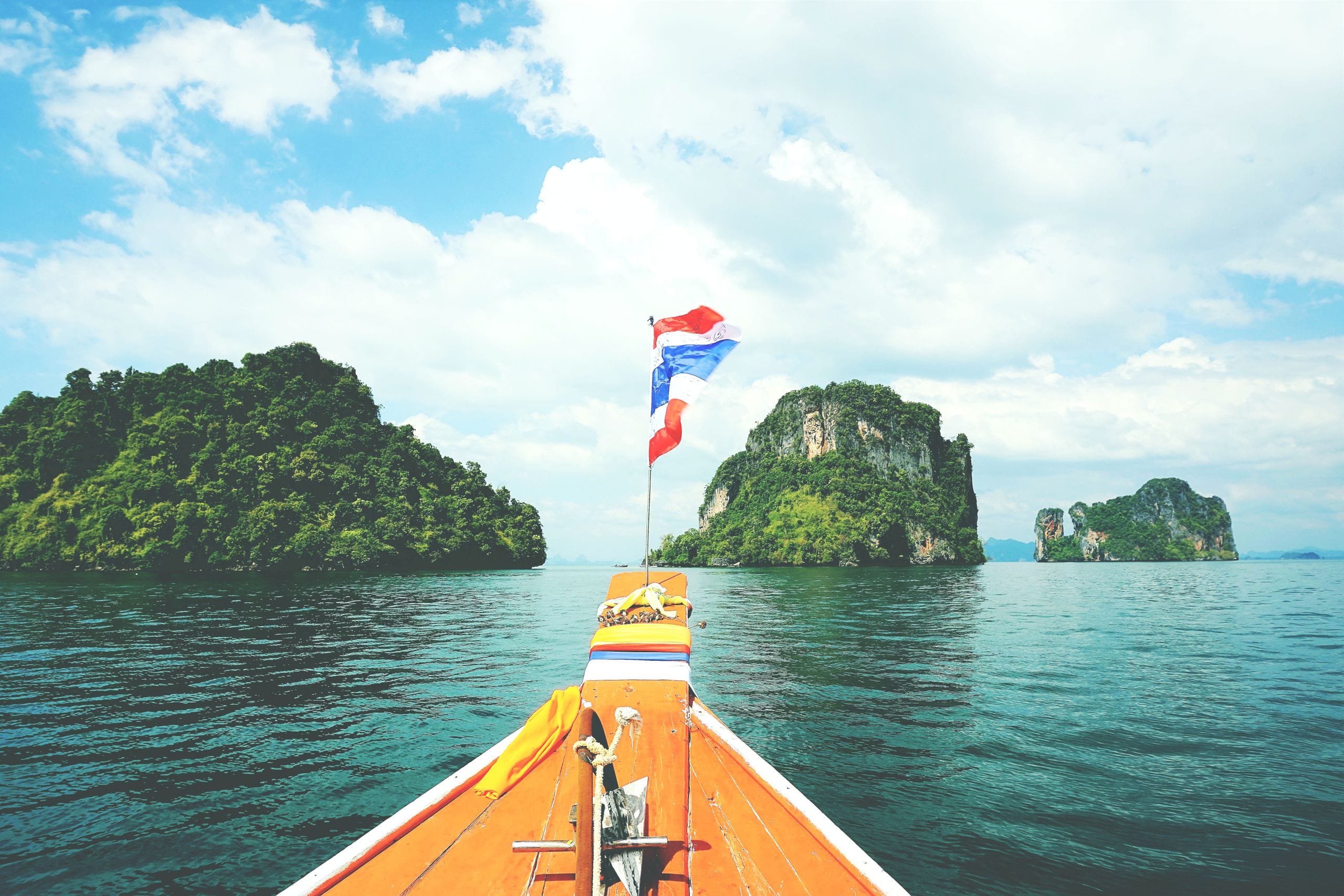 Longtail boat sailing between islands on the Andaman Sea