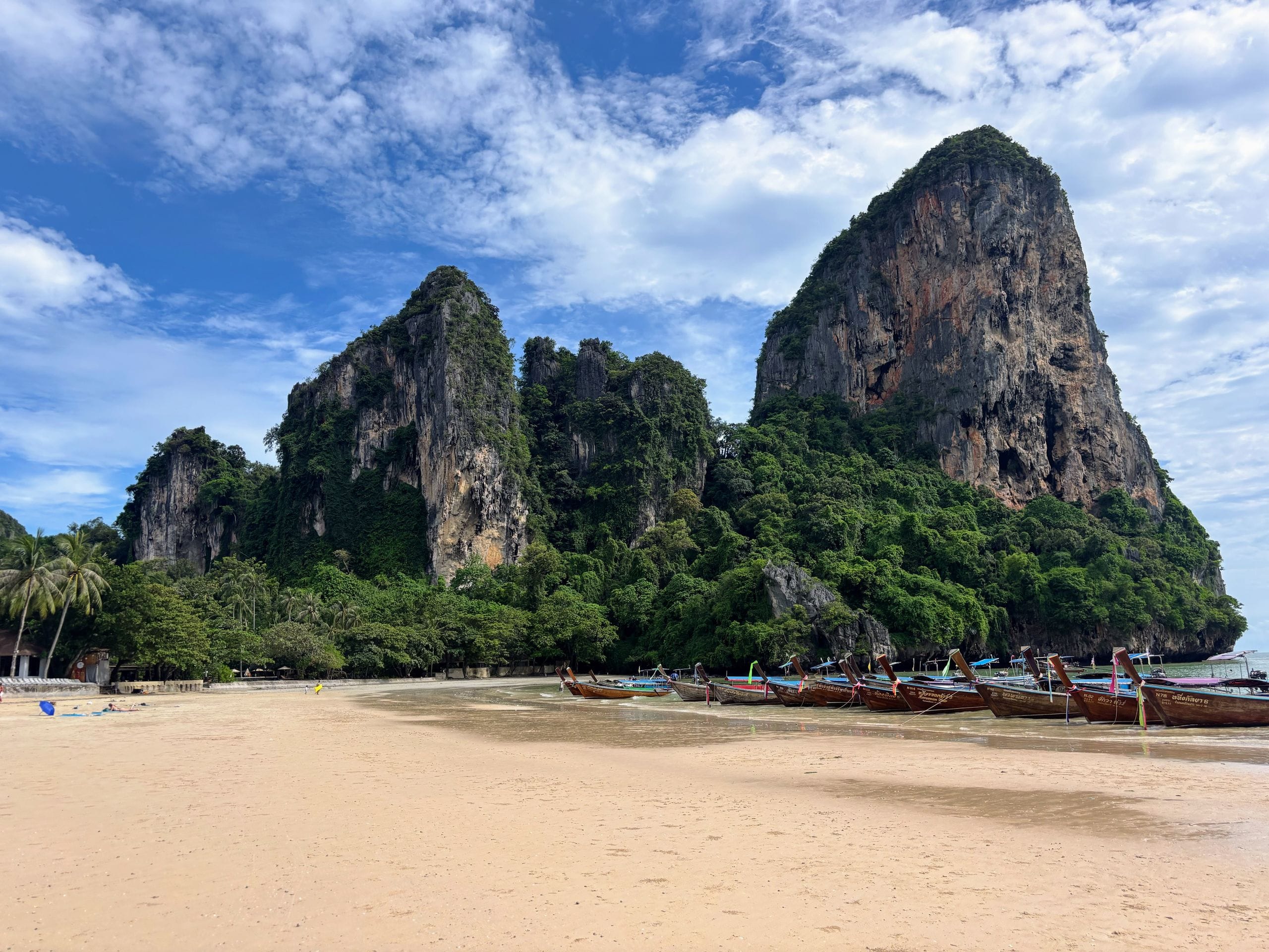 Longtail boats and limestone cliffs at Railay Beach, Krabi